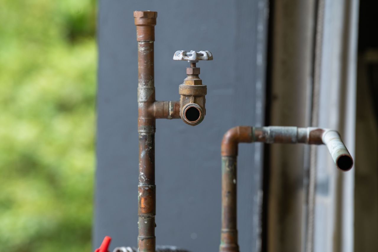Crafting Captivating Headlines: Your awesome post title goes here Detailed view of an old, rusty industrial water pipe with valve, conveying vintage industrial aesthetics.