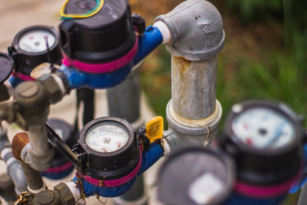 Home Detailed image of industrial water pressure gauges and pipes in an outdoor setting.
