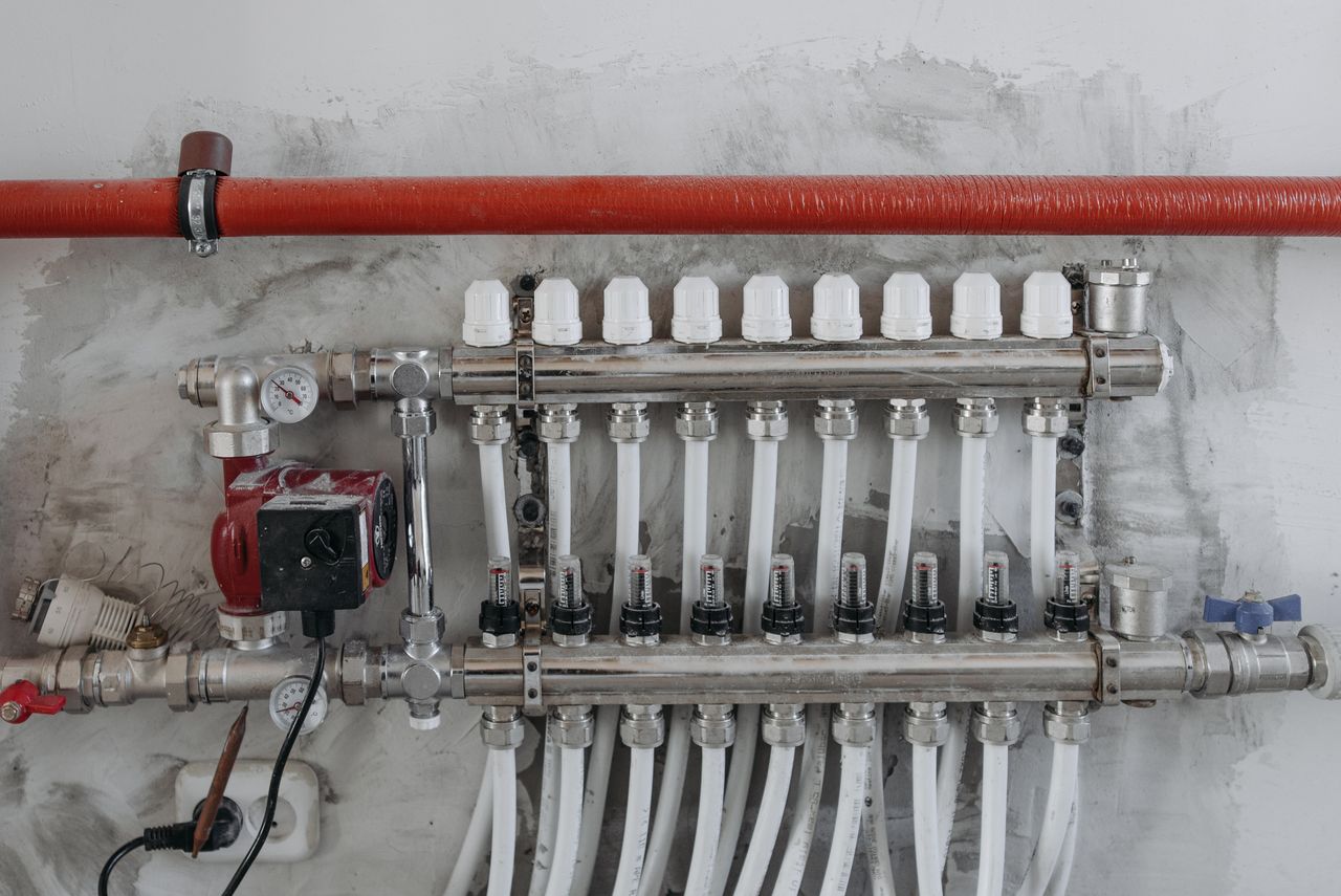 Home A close-up view of an industrial manifold with pressure gauges and connected steel pipes.
