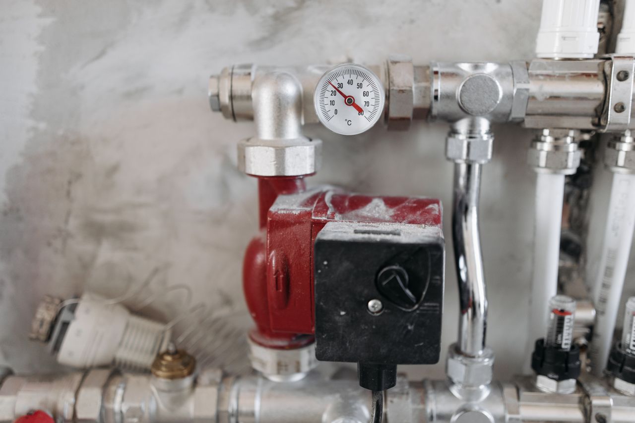 Home Close-up view of an industrial plumbing system featuring a pressure gauge and steel pipes.